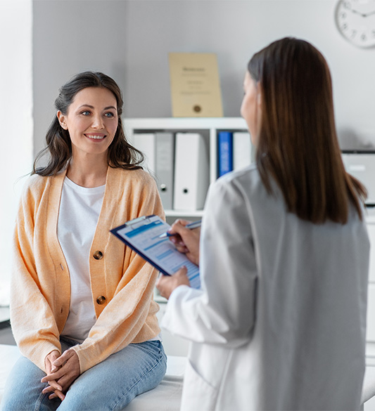 Ärztin im Aufklärungsgespräch mit sitzender Patientin – barrierefreies Patientenportal für Kliniken und Gesundheitsdienstleister nach WCAG 2.2