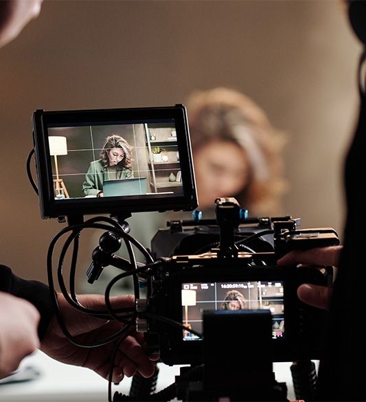 Kameramann filmt eine Frau bei einer Videoproduktion im Studio – barrierefreie Videoproduktion mit Audiodeskription und Untertiteln für Verlage und Rundfunkhäuser nach WCAG 2.2