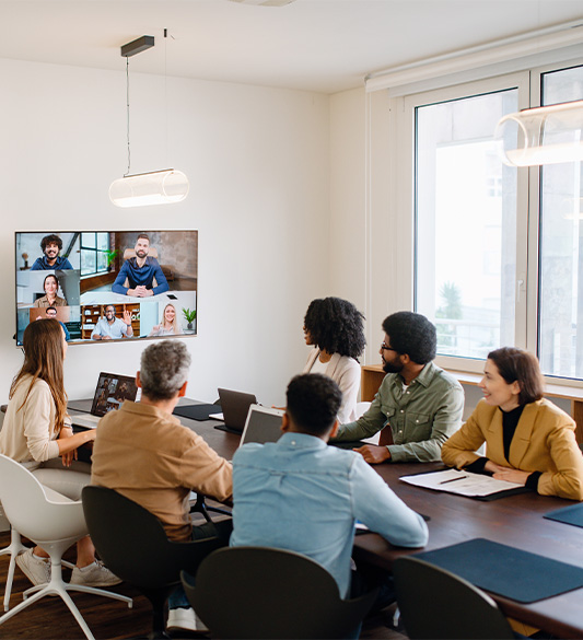 Diverse Gruppe von Mitarbeitenden im Besprechungsraum bei einem Video-Meeting – barrierefreie Kommunikationsdienste und Serviceportale für Unternehmen nach WCAG 2.2