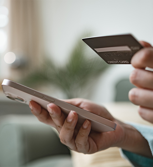 Hände halten ein Smartphone und eine Kreditkarte beim Online-Einkauf – barrierefreier Checkout im Online-Shop nach BFSG und WCAG 2.2
