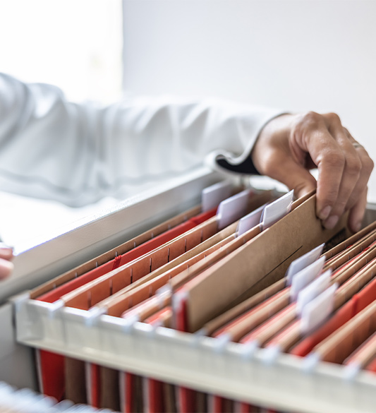 Hand greift durch eine Hängeregistratur mit Verwaltungsakten – barrierefreie amtliche Dokumente und Bescheide im PDF/UA-Format für Behörden nach WCAG 2.2