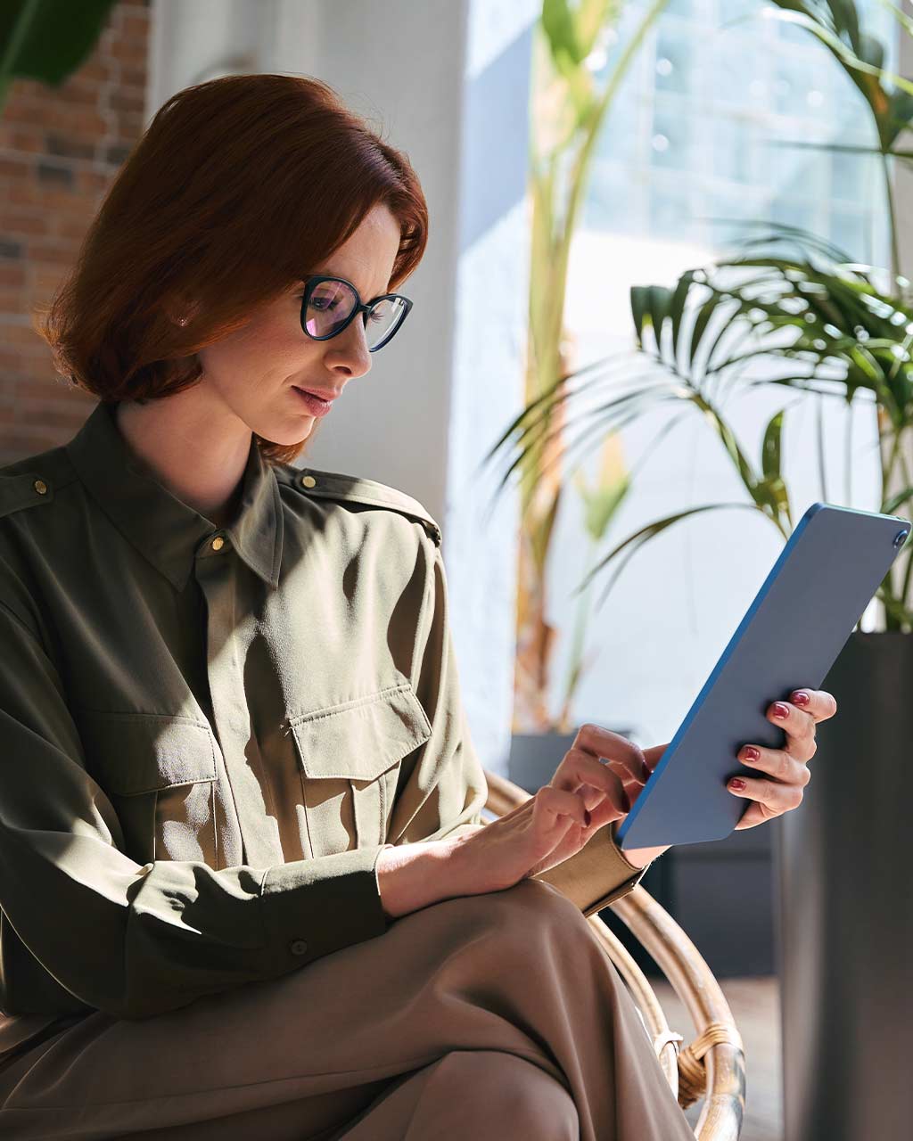 Frau mit Brille liest konzentriert auf einem Tablet – Access Overlay als sofortige Übergangslösung für BFSG-Konformität für Unternehmen, Enterprise und Digitalagenturen nach WCAG 2.2