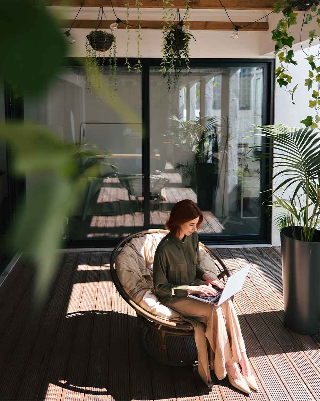 Frau sitzt im Sessel auf einer begrünten Terrasse und arbeitet am Laptop – kostenlose Website-Prüfung auf BFSG-Konformität mit Access Score® nach WCAG 2.2 für Mittelstand, Online-Händler und Agenturen