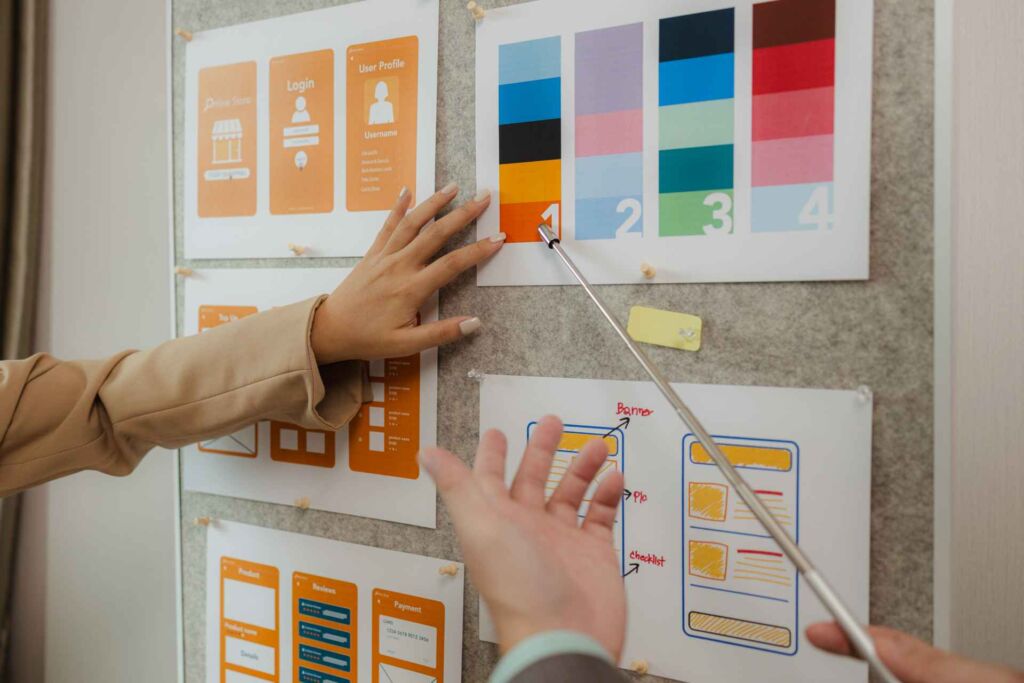 Hände ordnen UI-Wireframes und Farbkontrast-Karten an einer Pinnwand – WCAG 2.2 einfach erklärt: die wichtigsten Erfolgskriterien für kontrastreiche und zugängliche Webgestaltung nach BFSG
