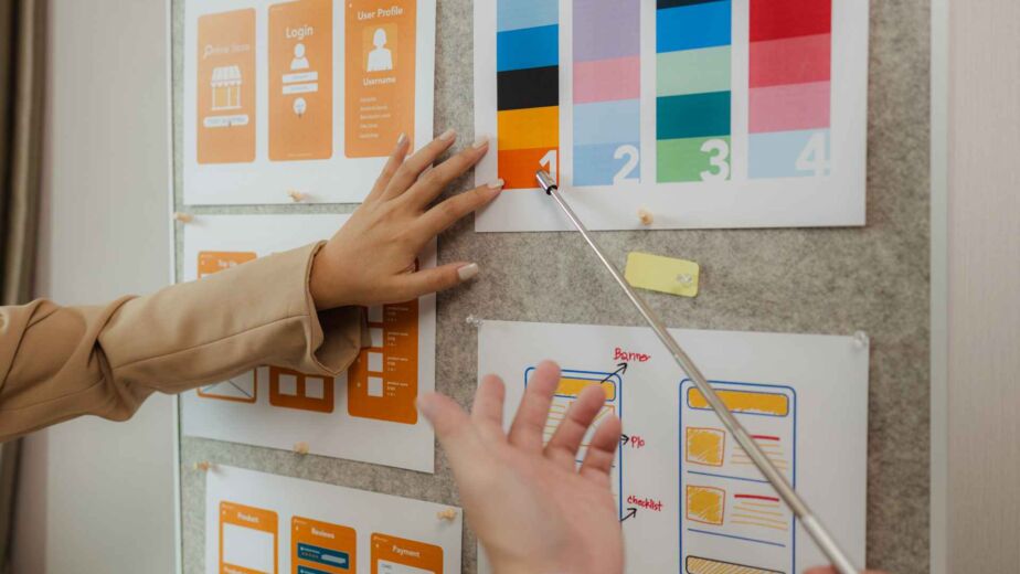 Hände ordnen UI-Wireframes und Farbkontrast-Karten an einer Pinnwand – WCAG 2.2 einfach erklärt: die wichtigsten Erfolgskriterien für kontrastreiche und zugängliche Webgestaltung nach BFSG