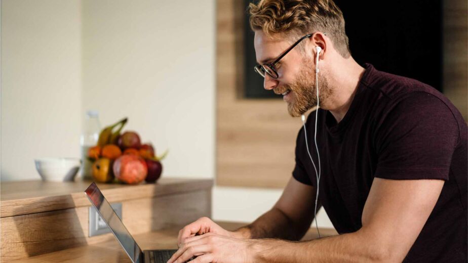 Mann mit Brille und Ohrhörern tippt konzentriert auf einem Laptop – Tastaturbedienung und Fokus-Management nach WCAG 2.2 für vollständig mausfreie Website-Navigation nach BFSG