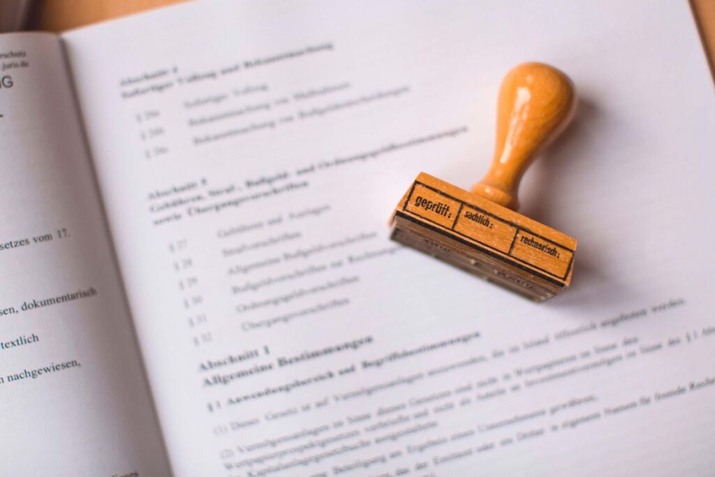 Prüfstempel 'geprüft' liegt auf Gesetzestext – belastbarer BFSG-Nachweis bei der Barrierefreiheits-Zertifizierung
