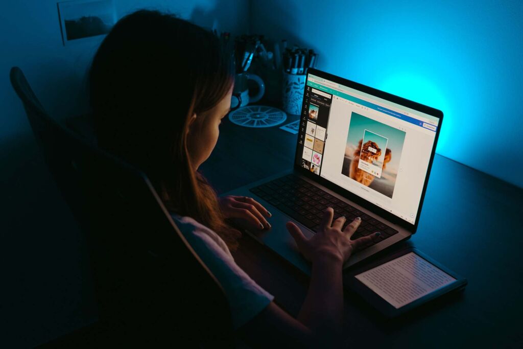 Person bearbeitet Bild in Design-Tool am Laptop bei Nacht – Alt-Texte richtig schreiben für jedes Bildmotiv