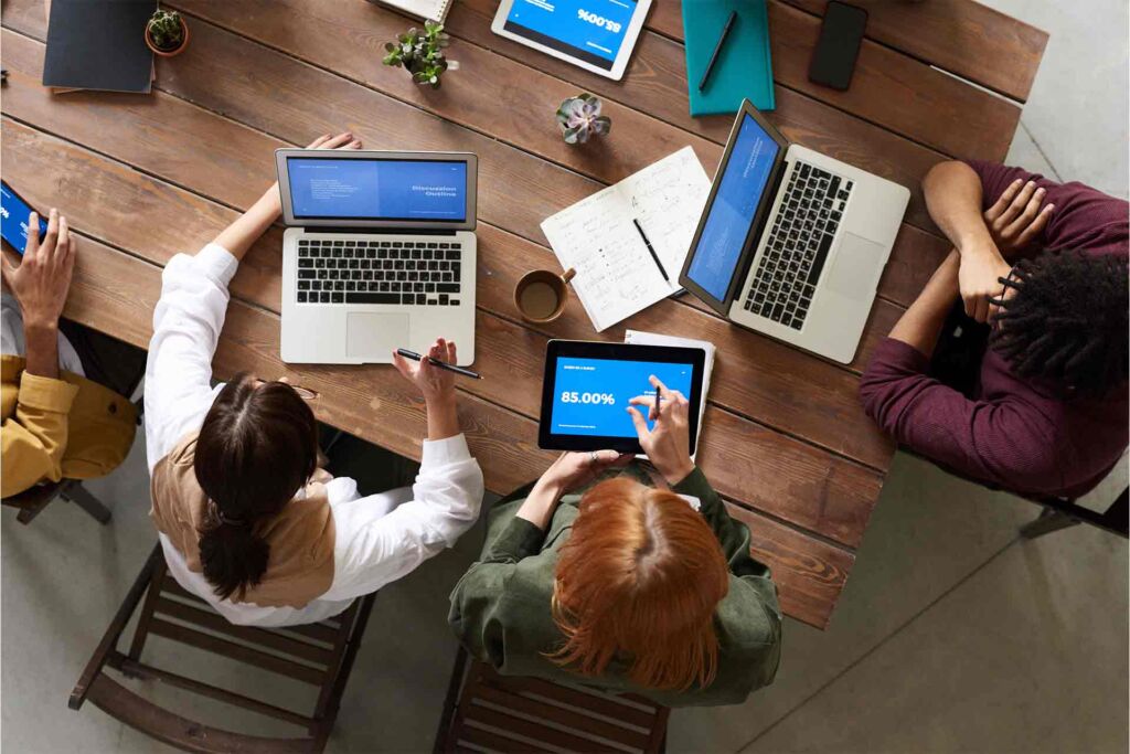 Team bespricht Strategie mit Laptops und Statistiken am Tisch – Barrierefreiheit-SEO: beide Disziplinen zusammen