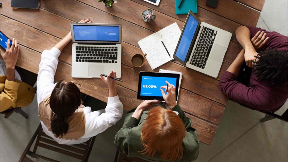 Team bespricht Strategie mit Laptops und Statistiken am Tisch – Barrierefreiheit-SEO: beide Disziplinen zusammen