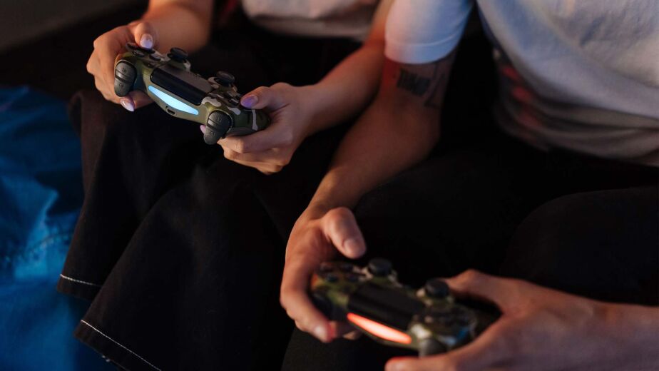 Personen spielen mit Controllern auf der Couch – barrierefreies Gaming: Spiele für alle spielbar machen