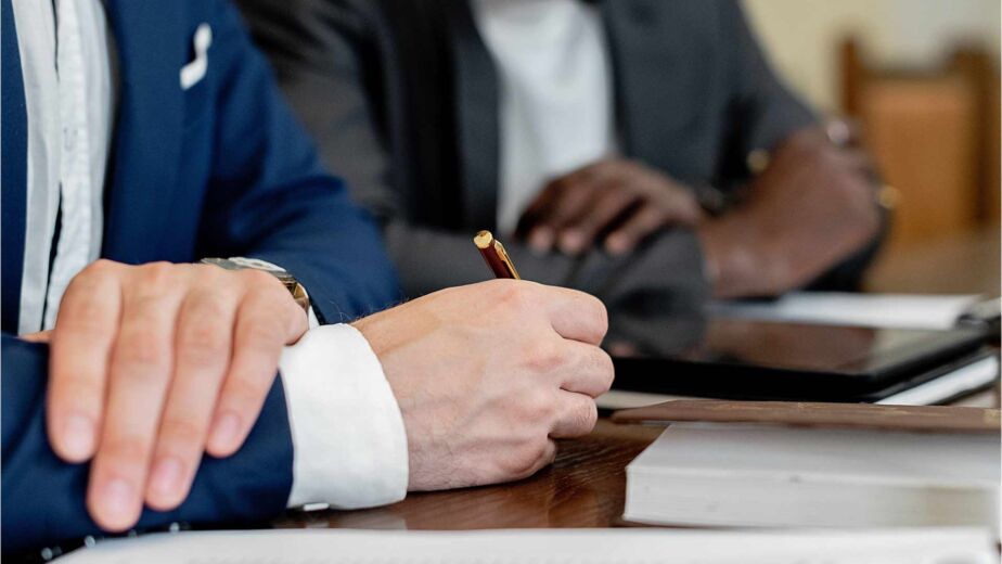 Hand hält Stift über Dokument im Geschäftstermin – Barrierefreiheit-Zertifizierung: welcher Nachweis zählt