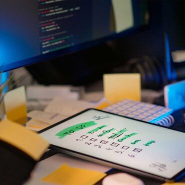 Nummerierte Checkliste mit Häkchen auf Tablet neben Code-Bildschirm – WCAG-Checkliste Punkt für Punkt prüfen