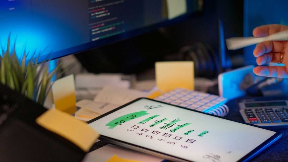 Nummerierte Checkliste mit Häkchen auf Tablet neben Code-Bildschirm – WCAG-Checkliste Punkt für Punkt prüfen