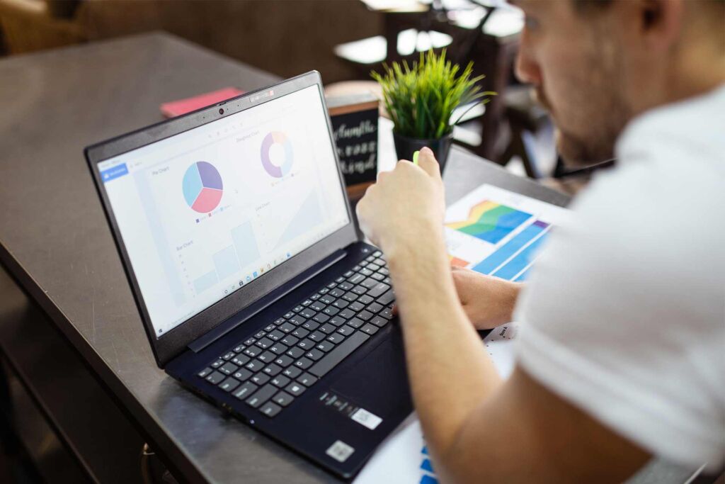 Mann prüft Diagramme mit Kreis- und Balkendarstellung am Laptop – WCAG-Konformität Stufen und Nachweis