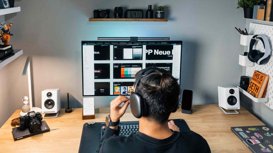 Designer mit Kopfhörern arbeitet am Monitor mit Farbpalette – WCAG 2.2 Trends für digitale Barrierefreiheit