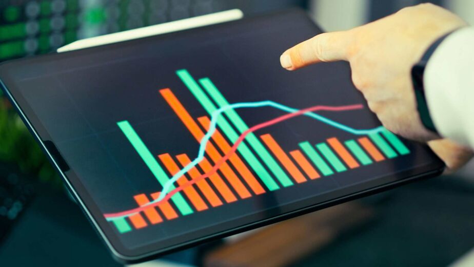 Hand zeigt auf Balken- und Liniendiagramm am Tablet – wirtschaftlicher Nutzen der Barrierefreiheit in Zahlen